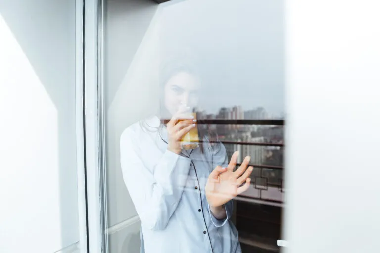 pretty young lady standing home looking window 768x512 1