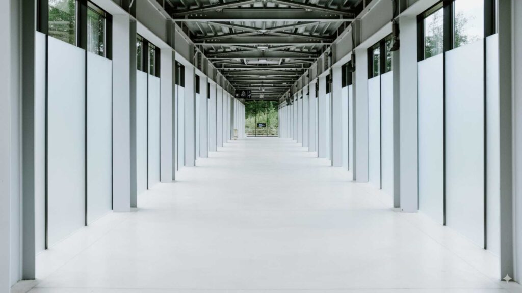 Modern living room with plants and large white blinds.