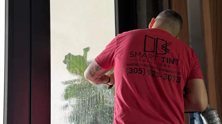 A professional installs solar window film in a miami home